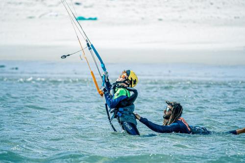 two people in the water playing with a windsurfer at Océan Vagabond Lassarga in Dakhla