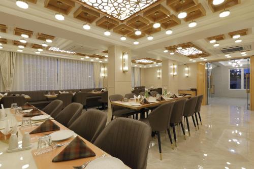 un ristorante con tavoli e sedie in una stanza di Hotel Elysian Residency a Ahmedabad