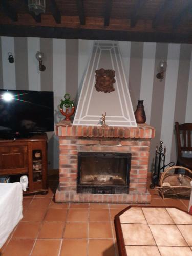 a living room with a fireplace and a tv at Casa de Aldea Florentina in Arenas de Cabrales