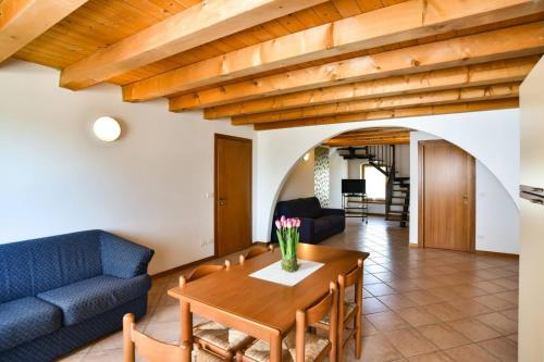 a living room with a table and a blue couch at AGRITURISMO COLOMBARE TEBOI in Lazise