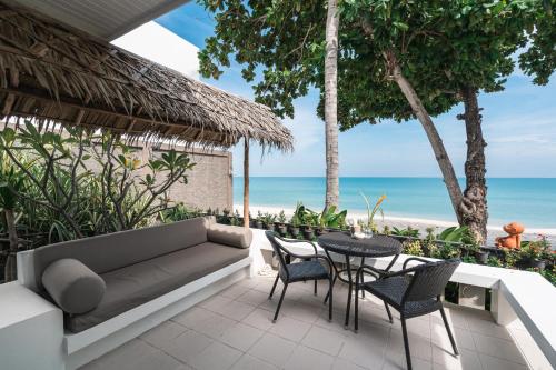 a patio with a couch and chairs and the beach at King's Garden Resort - SHA Plus in Chaweng