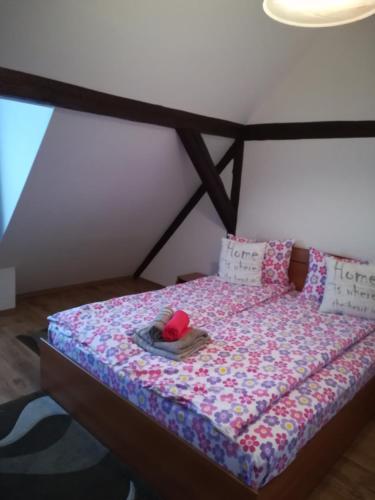 a bed in a room with a bedspread with a hat on it at Casa Maria in Şura Mică