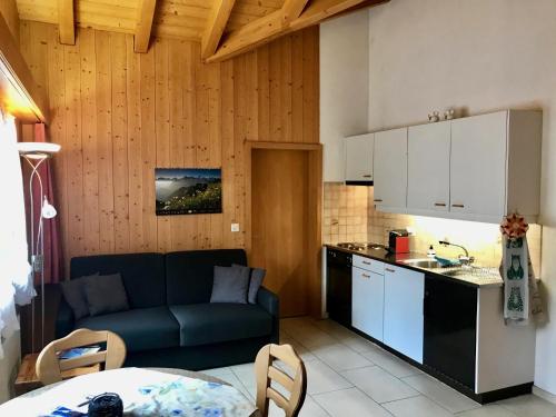 a living room with a couch and a kitchen at Am Eigen in Grindelwald