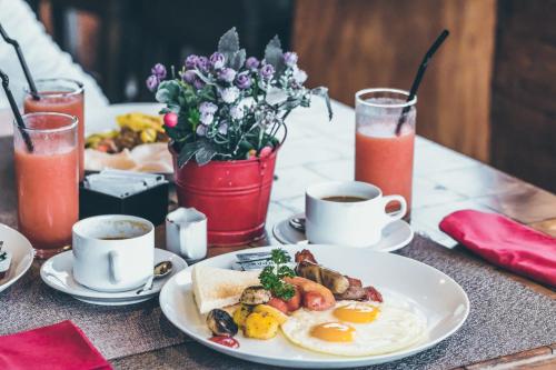 a table with a plate of breakfast food and drinks at BluSalzz Homes - The Himalayan Bungalow, Almora - Uttarakhand in Almora