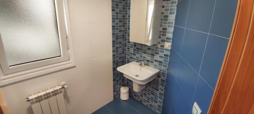 ein kleines blau gefliestes Badezimmer mit Waschbecken in der Unterkunft HOLIDAY HOMES by del abuelo VEGADEO in Vegadeo