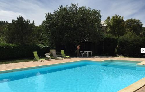 a swimming pool with chairs and a table and a person at Gîte Ciel Bleu Château d'Allemagne En Provence in Allemagne-en-Provence