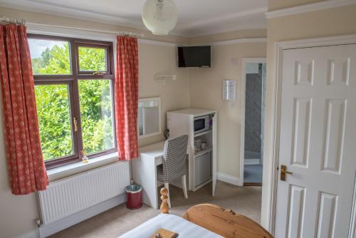 イプスウィッチにあるToothbrush Rooms at Lattice Lodge - Guest Kitchen & EV Rechargingの窓とテーブルが備わる客室です。