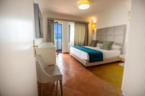 a hotel room with a bed and a chair in it at Hotel Oasi Di Kufra in Sabaudia