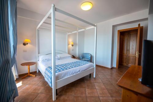 a bedroom with a canopy bed and a table at Hotel Oasi Di Kufra in Sabaudia