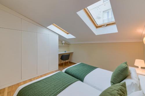 a attic bedroom with two beds and a skylight at Holidays2Malaga Soho Penthouse in Málaga