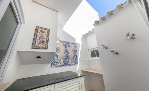 een keuken met witte muren en een trap met een raam bij Casa Feliz in Lagos in Lagos