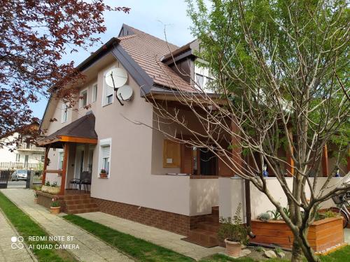 a white house with a brown roof at Forrás-G Vendégház in Bük