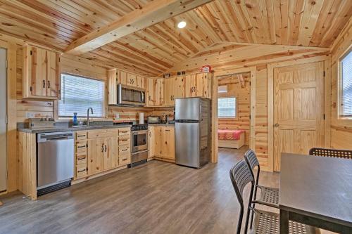 a kitchen with wooden cabinets and a stainless steel refrigerator at Cozy Bidwell Cabin with Deck Trail and Creek Access! in Bidwell