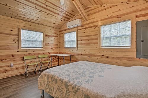 a bedroom with a bed and a table and chairs at Cozy Bidwell Cabin with Deck Trail and Creek Access! 