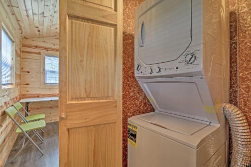 a kitchen with a washer and dryer in a tiny house at Cozy Bidwell Cabin with Deck Trail and Creek Access! in Bidwell