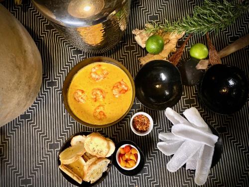 a table with a bowl of soup and a plate of food at Soleluna Casa Pousada in Trancoso