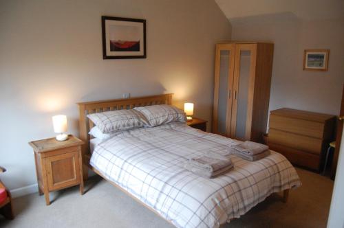 1 dormitorio con 1 cama con 2 mesitas de noche y 2 lámparas en The Old Bakehouse en Newcastleton