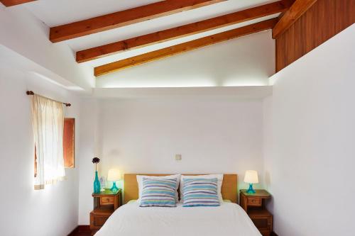 a bedroom with a white bed with two pillows at Casa da Pedra Rolada in Janeiro de Cima