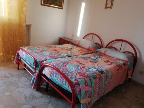 a bedroom with a bed with a colorful quilt at Casa Santinelli in Falconara Marittima