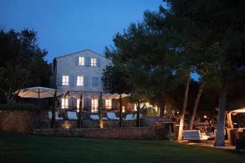 a house with chairs and umbrellas at night at Boutique Hotel Boškinac in Novalja