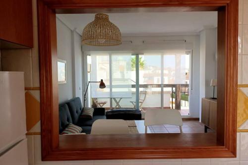 a mirror reflecting a living room with a couch and chairs at A TU VERA Apartamento en Vera Playa in Playas de Vera