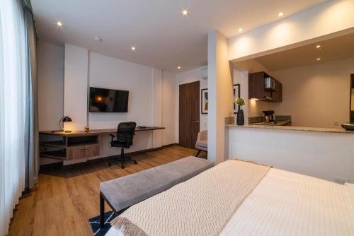 a bedroom with a bed and a desk with a computer at Cali River Suites by Yellowkey Capital in Cali