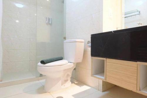 a bathroom with a toilet and a flat screen tv at Cozy & Elegant The Mansion Jasmine Tower Capilano in Jakarta