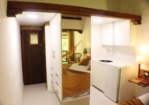 une petite cuisine avec une porte menant à une chambre dans l'établissement Pousada Dos Artistas, à Praia do Forte