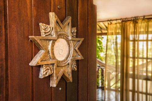 a wooden cross on a wooden wall at Pousada Dos Artistas in Praia do Forte