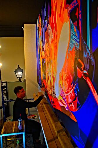 a man is painting a painting on a wall at All Iron Hostel in Bilbao