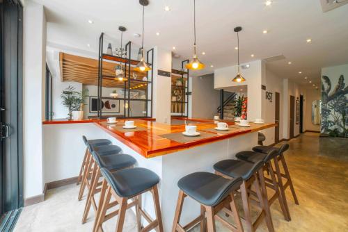 a kitchen with a bar with wooden counter and stools at Cali River Suites by Yellowkey Capital in Cali