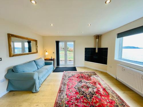 a living room with a blue couch and a television at Loch Morar Private Suite in Mallaig