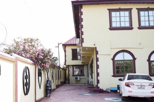 a white car parked in front of a building at Gya-son Royal Guest House in Kumasi