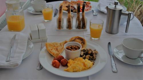 a table with a plate of breakfast food and orange juice at The Sands B&B Rostrevor in Rostrevor
