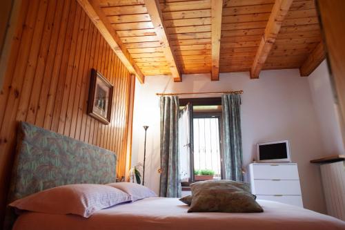 a bedroom with a bed with a wooden ceiling at Casa Vacanza Scacco d' Argento in Boario Terme