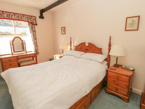 a bedroom with a bed and a dresser and a window at Foxglove Covet in Wooler