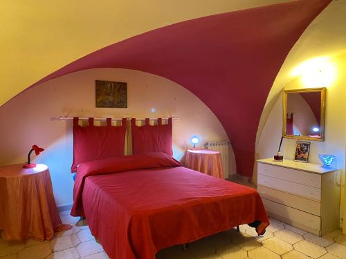 1 dormitorio con 1 cama roja y 2 lámparas en Antica Casa Centro, en Catania