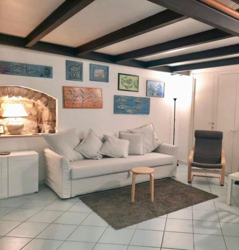 sala de estar con sofá blanco y silla en A Casa di Paola en Gaeta