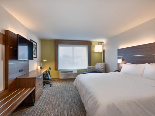 Holiday Inn Express & Suites Salem North - Keizer, an IHG Hotel في Keizer: غرفه فندقيه سرير كبير وتلفزيون