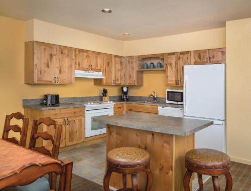 a kitchen with wooden cabinets and a white refrigerator at WorldMark Running Y in Klamath Falls