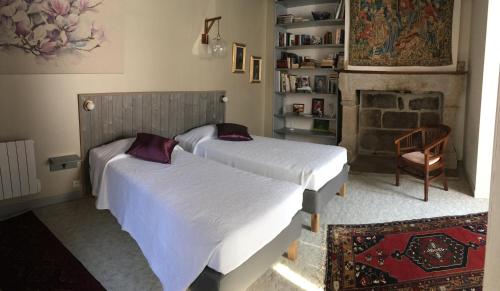 2 Betten in einem Schlafzimmer mit Kamin in der Unterkunft La Maison des Matignon 1 in Granville