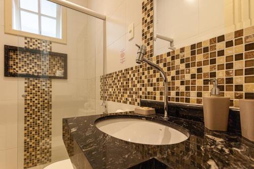 a bathroom with a sink and a shower at Pousada Casablanca in Abraão