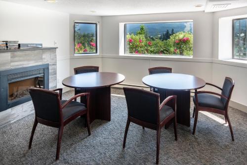 a room with two tables and chairs and a fireplace at The Ironwood on Blueberry Hill in Whistler