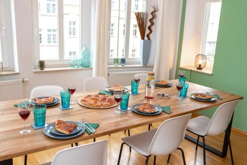 une table en bois avec des assiettes de nourriture dans l'établissement Kaßberg Apartment im Retro-Stil / Netflix & WIFI, à Chemnitz
