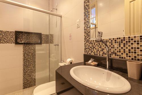 a bathroom with a sink and a toilet and a shower at Pousada Casablanca in Abraão