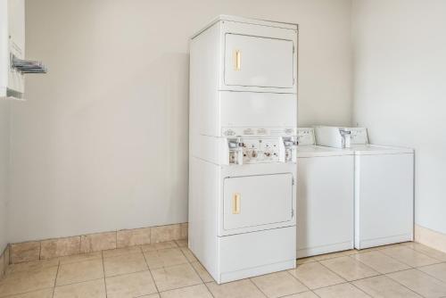 a white refrigerator freezer sitting next to a wall at Red Roof Inn & Suites Lake Charles in Lake Charles