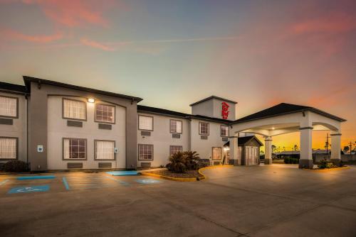 a hotel with a parking lot in front of it at Red Roof Inn & Suites Lake Charles in Lake Charles
