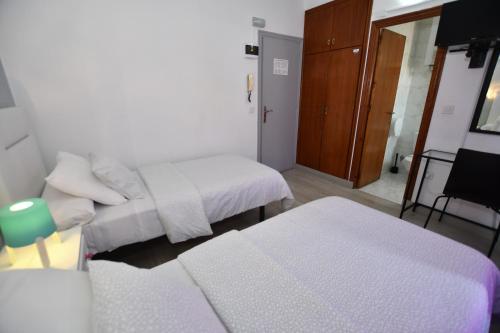 a small room with two beds and a table at HB Torrevieja in Torrevieja