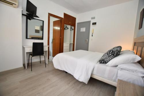 a bedroom with a bed with a desk and a chair at HB Torrevieja in Torrevieja