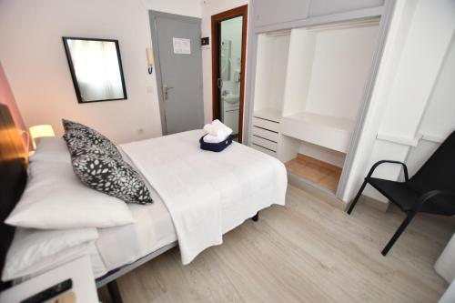 a bedroom with a bed and a chair and a mirror at HB Torrevieja in Torrevieja